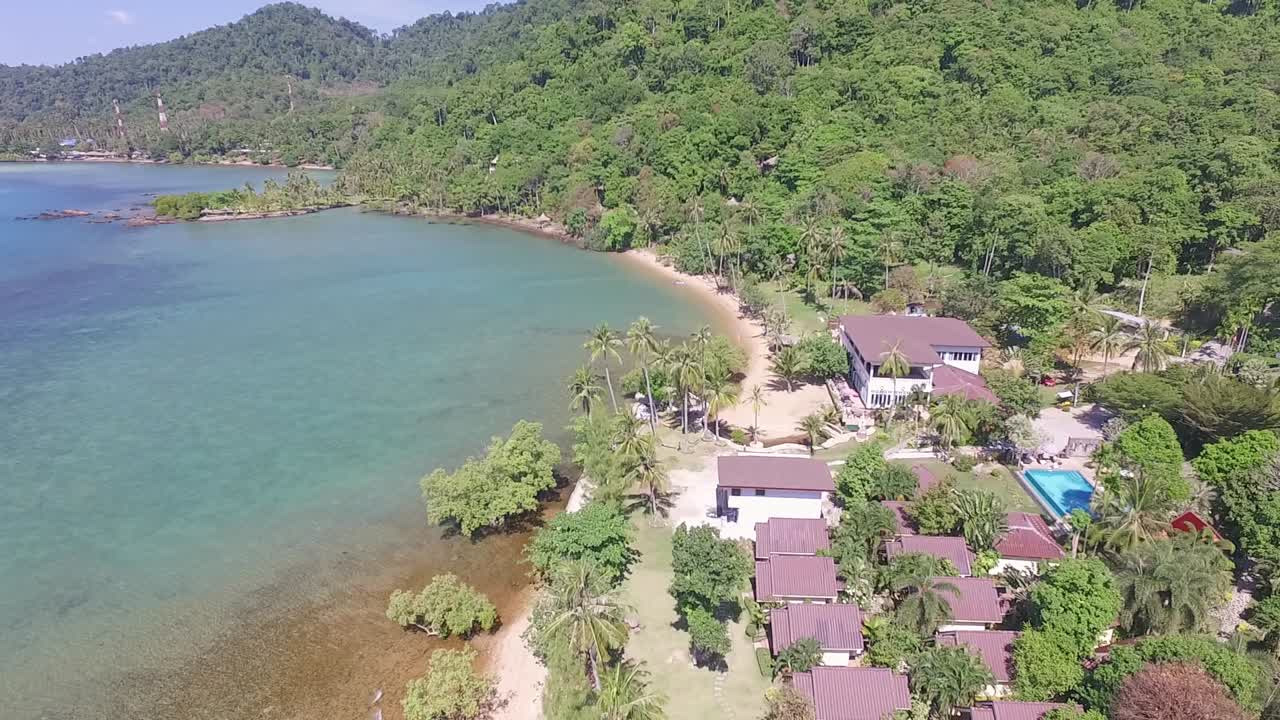 Aerial shot of small beach resort on tropical Island with beach, palm trees and jungle