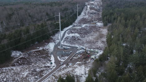 aerial view of new power line installation in winter forest