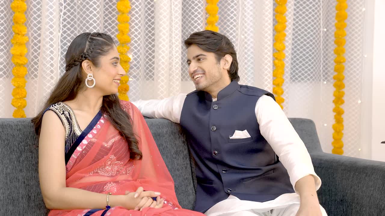 una pareja india feliz hablando entre sí.