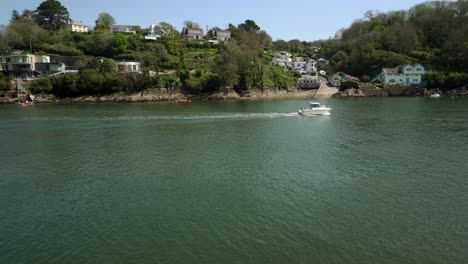 gazing across the fowey estuary, river at bodinnick with a fast motor boat crossing the scene on a hot spring day