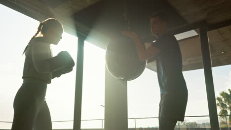 entrenador personal de fitness con una mujer boxeadora en lente