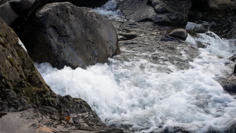 rocky waterfall river creek rushing over boulders in seasonal autumn woodland pull back slow