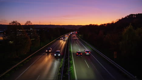 time lapse static shot from a bridge onto a busy highway with a lot of traffic with cars and trucks during the sunset in the holiday evening traffic