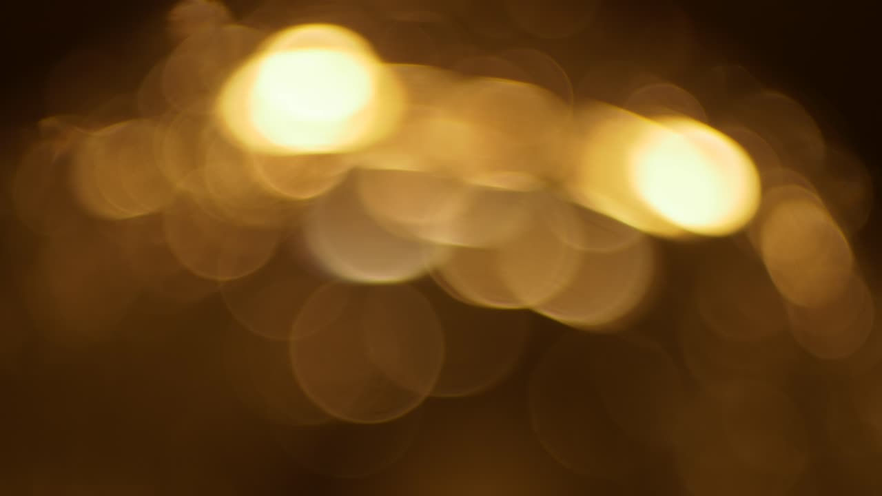Luci bokeh dorate astratte scintillanti su sfondo scuro