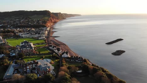 toma aérea de la ciudad de sidmouth devon inglaterra al amanecer bañada por un sol dorado