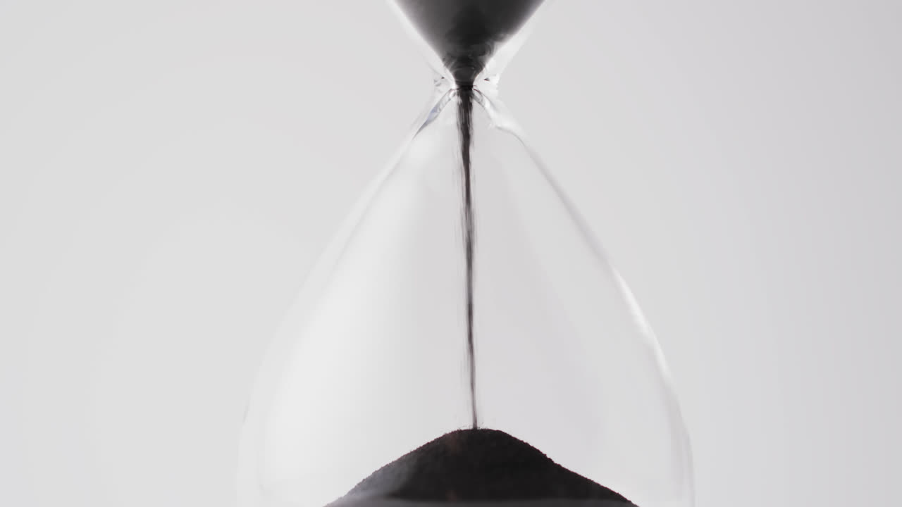 Video of hourglass with sand pouring, copy space on white background
