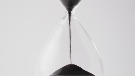 video of hourglass with sand pouring, copy space on white background