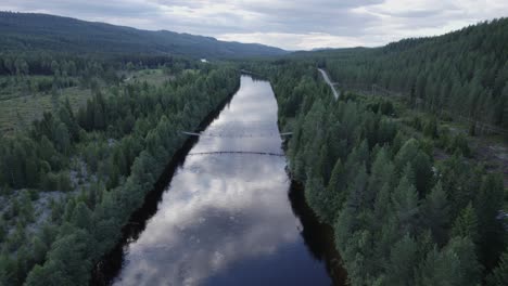 scenic aerial footage of valley and river on a cloudy day in norway