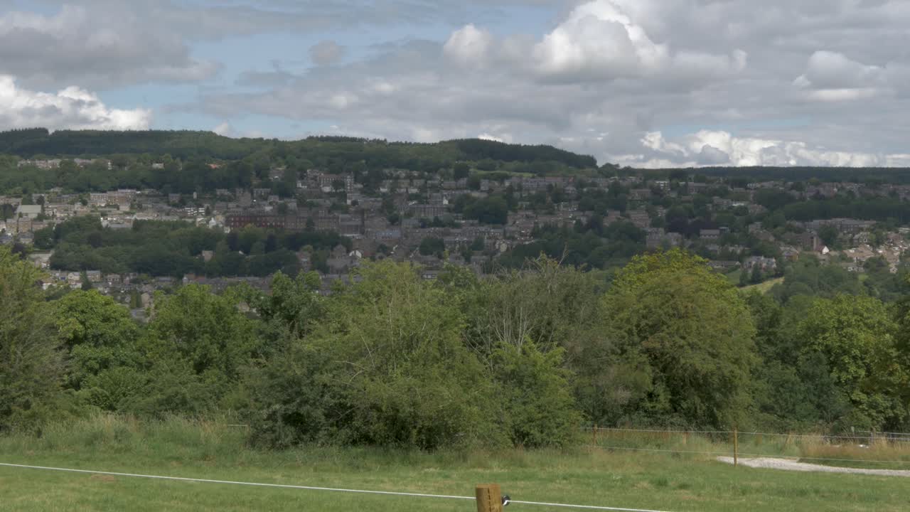 British village built on a hill seen from a distance.