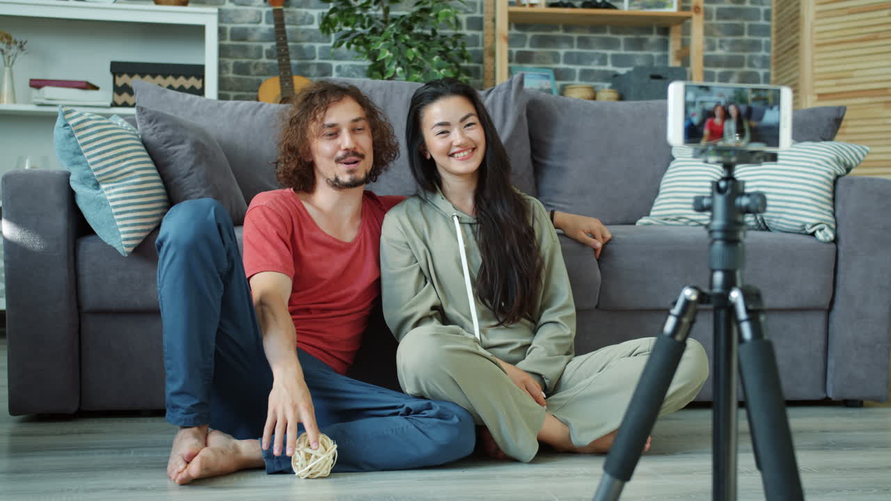 Couple recording a video in their living room
