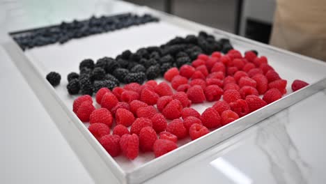 a baker organizing fresh berries showcased for cake and muffin toppings at a local bakery