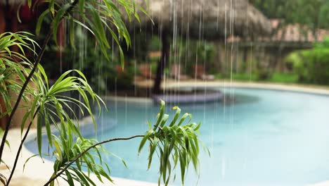 rain falls in a tropical beach resort with swimming pool in costa rica