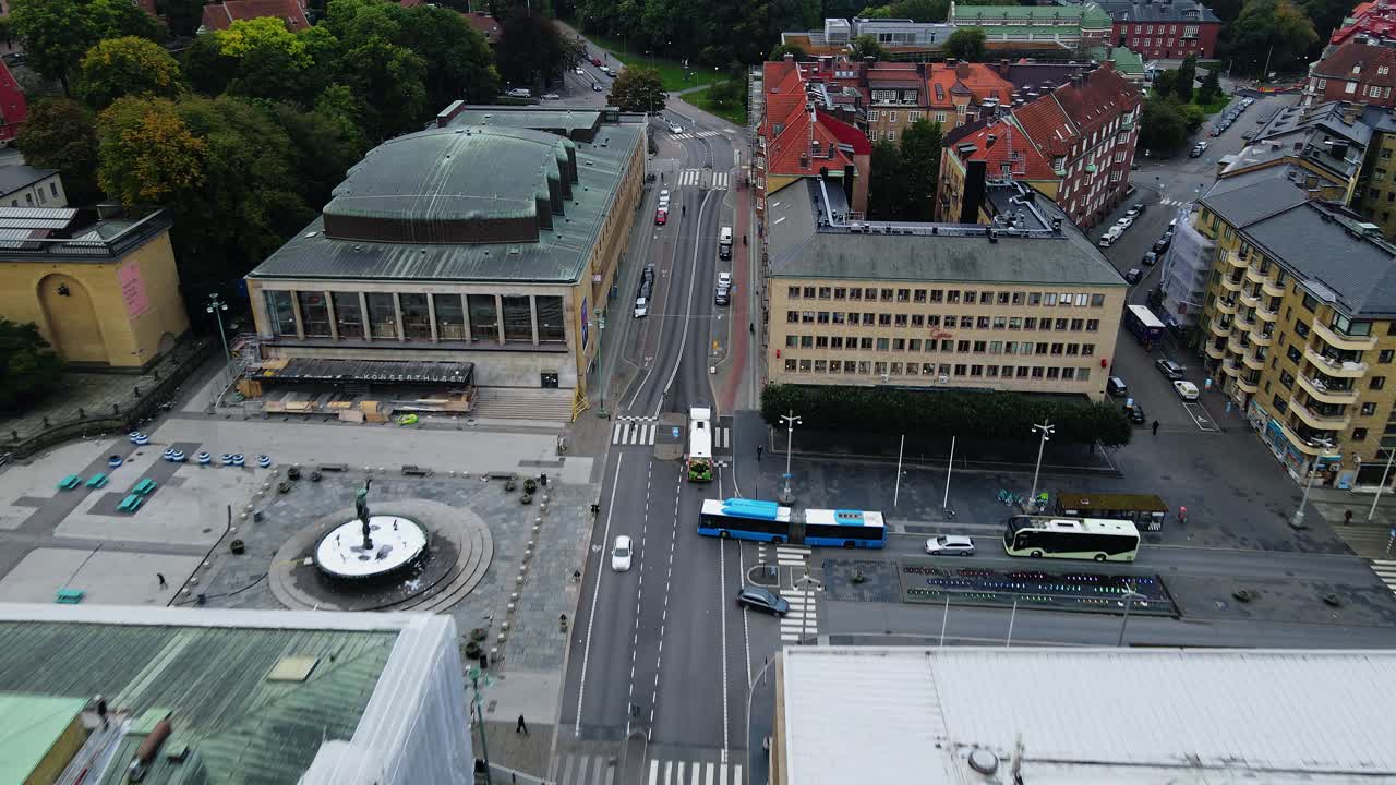 vehículos y tranvías que viajan por la carretera de la ciudad cerca de la sala de conciertos de gotemburgo y la estatua de poseidón en gotaplatsen en el centro de gotemburgo, suecia