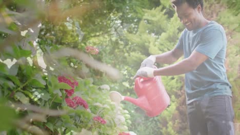 animation of trees over happy biracial man with watering can in garden