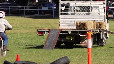 rider jumps hay bales on motorcycle in competition