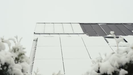 gimbal arriba revelando varios paneles solares de una casa cubierta de nieve después de una tormenta de nieve