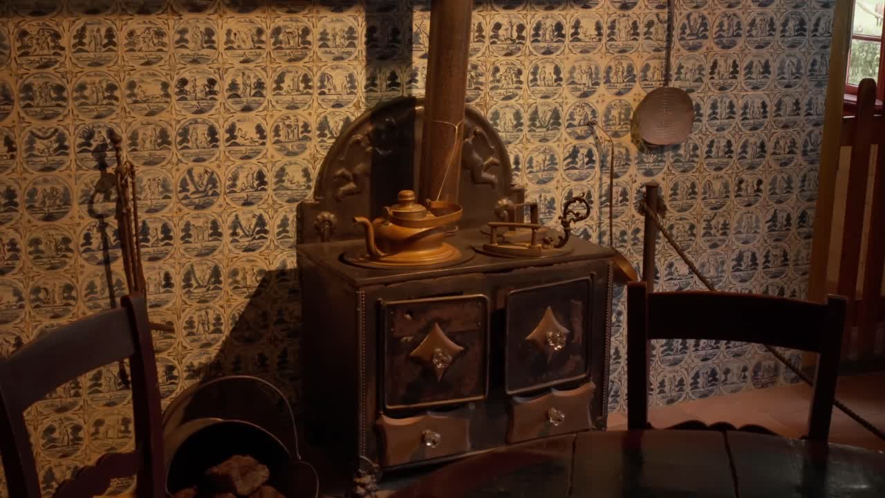 Interno di un'antica cucina olandese con tradizionali piastrelle blu e bianche e bollitore in rame sulla stufa nell'Open Air Museum di Arnhem, Paesi Bassi. Scena domestica storica