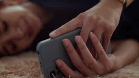 Woman-laying-on-the-carpet-with-the-phone