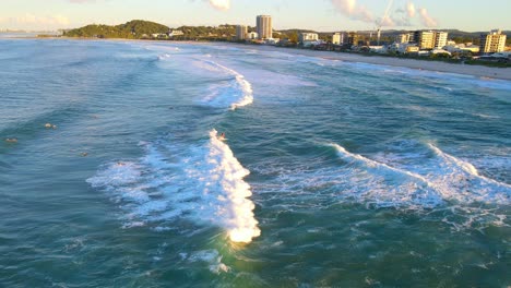 Rauschende-Wellen,-Die-Von-Den-Surfern-Genossen-Werden,-Die-Während-Des-Sonnenaufgangs-Surfen---Surfspot-Am-Palm-Beach-In-Qld,-Australien