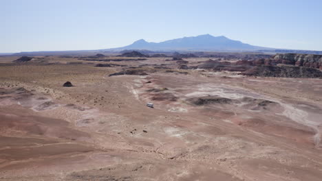 An-aerial-drone-shot-of-an-RV-off-road-driving-through-the-Utah-desert-on-an-American-roadtrip