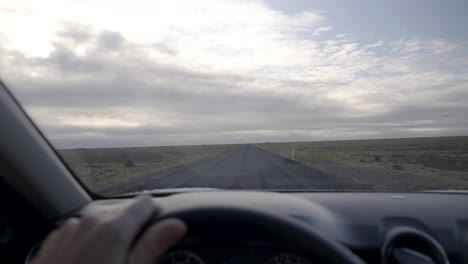 conduciendo por una remota carretera islandesa, un vasto paisaje abierto por delante
