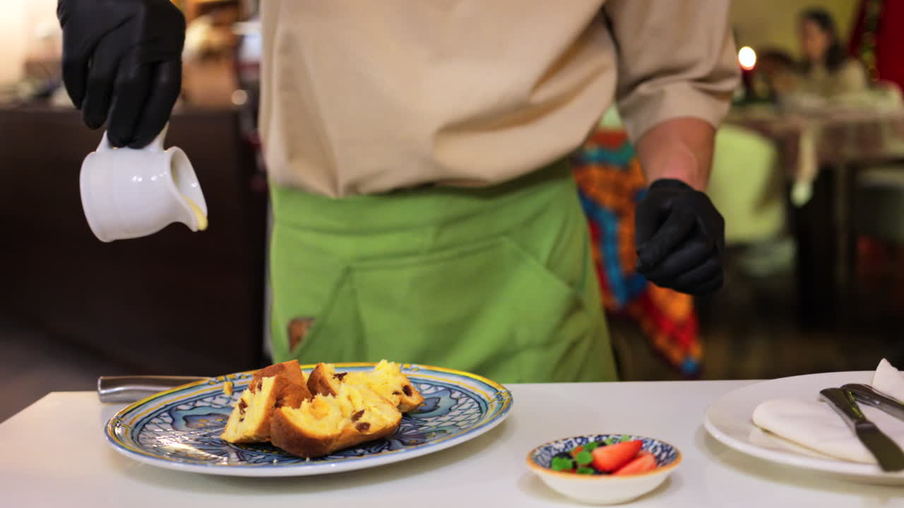 Cameriere che versa latte condensato su diversi pezzi di panettone al ristorante