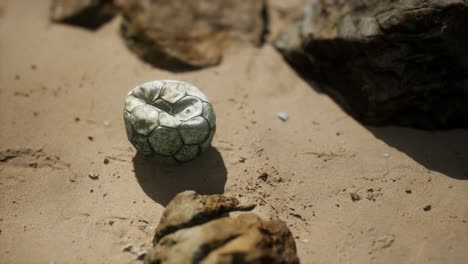 old-football-ball-on-the-sand-beach