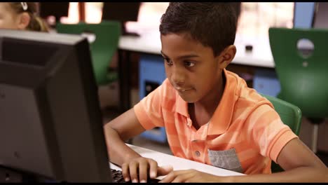 escolar que estudia en una computadora personal en el aula