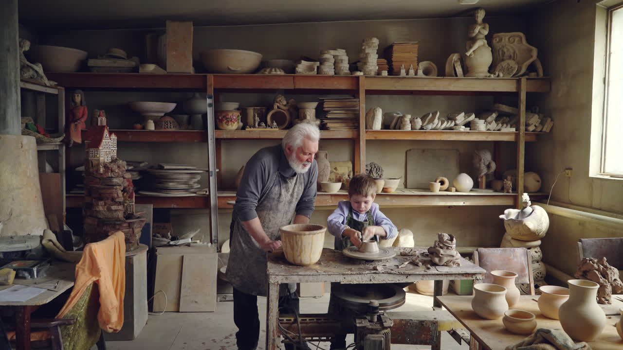Grandfather and grandson working together in a pottery studio