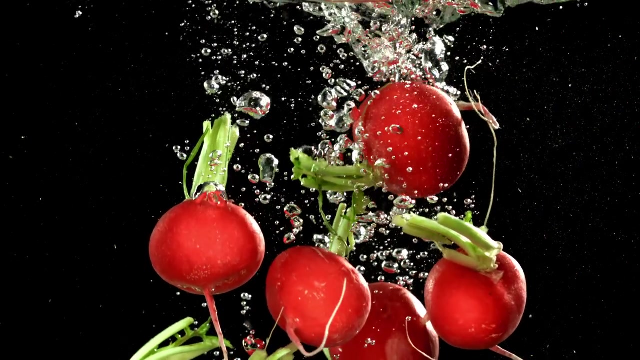 Fresh Red Radishes Falling into Water with Bubbles