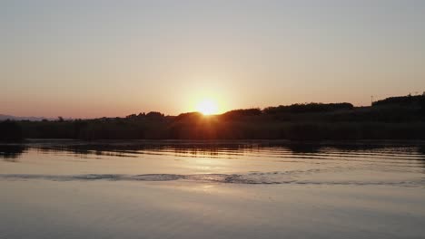 Pelikan-Schwimmt-Und-Fliegt-Bei-Sonnenaufgang-Auf-Einem-See