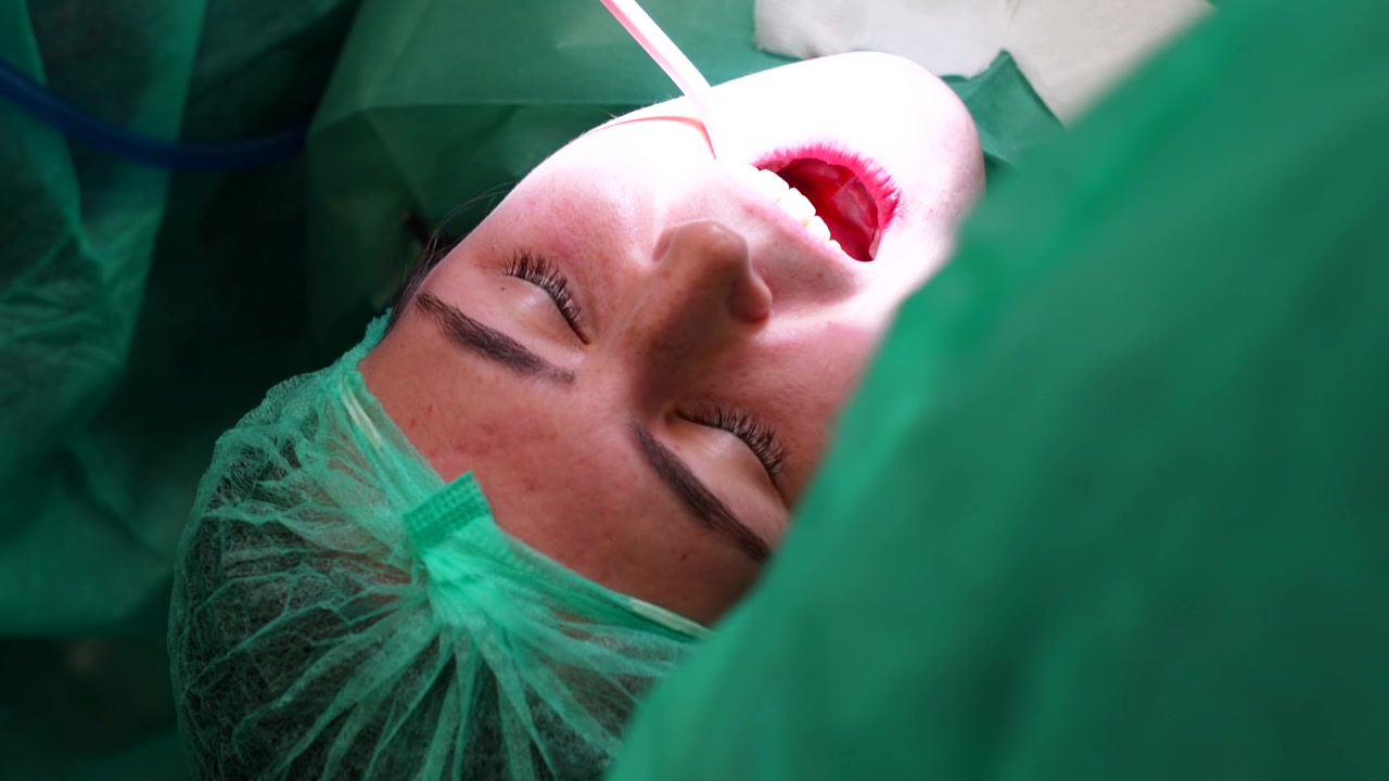Procedura di chirurgia odontoiatrica con paziente anestetizzato in un ambiente clinico