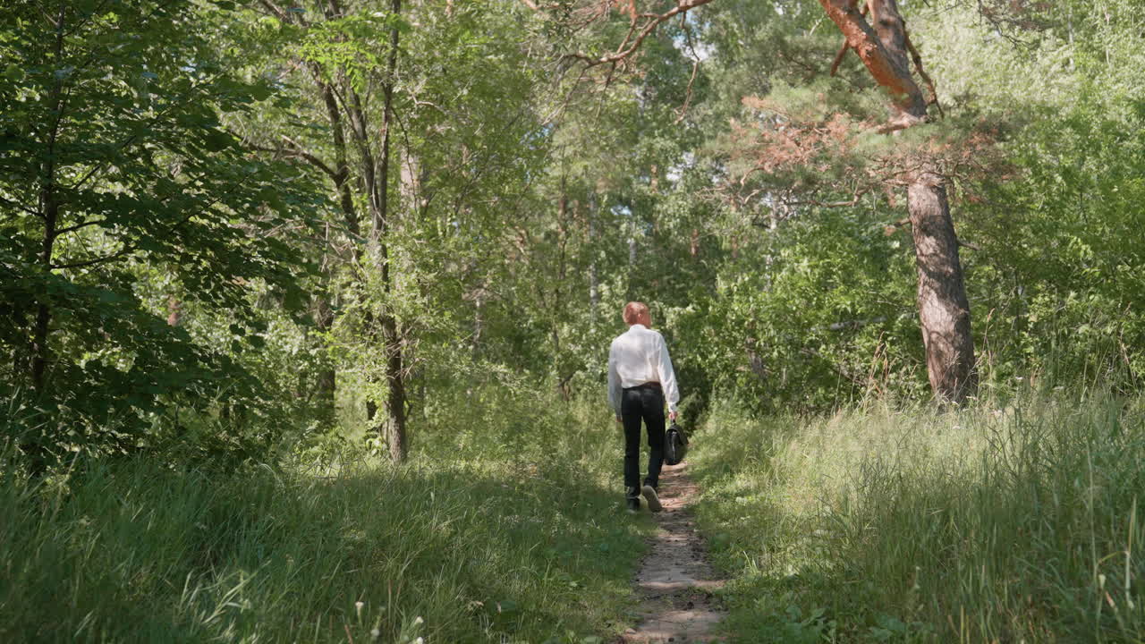 A businessman walking through a forest