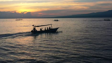 Silueta-Aérea-De-Turistas-En-Botes-Jukung-Indonesios-En-Lovina-Bali-Al-Amanecer-En-Busca-De-Delfines