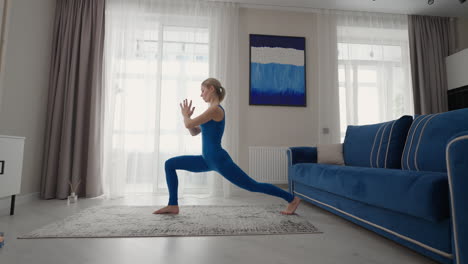 entrenamiento de yoga en casa en la alfombra por la tarde cerca del sofá y la televisión en la sala de estar. ejercicios matutinos y clase de yoga. ejercicios complejos de yoga para el equilibrio y la resistencia