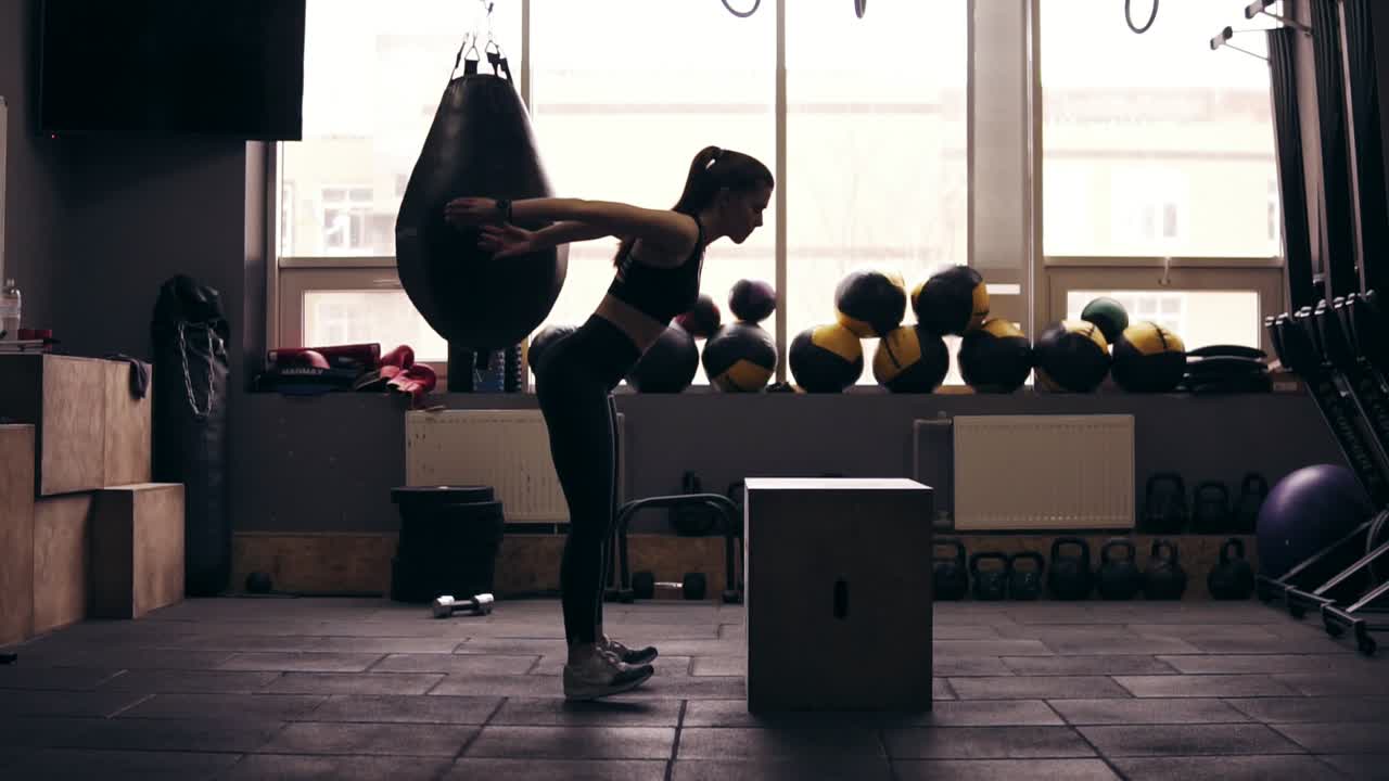 Attractive sportive girl in her 20's jumping up on cubicle at the gym. Gettig ready for summer season. Healthy lifestyle, fitness and wellbeing.