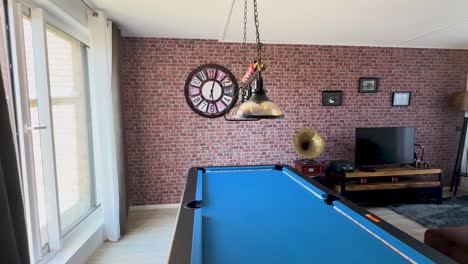 camera slowly pans across a sunlit lounge with a blue billiard table, vintage decor, exposed brick wall, and large windows, creating a cozy retro atmosphere