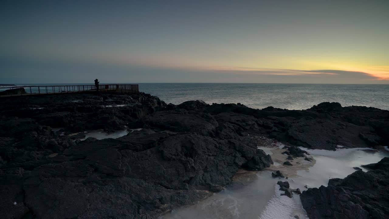 pareja romántica viendo la hermosa puesta de sol junto al océano