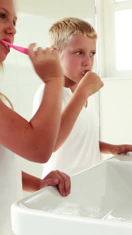 hermanos lavándose los dientes juntos