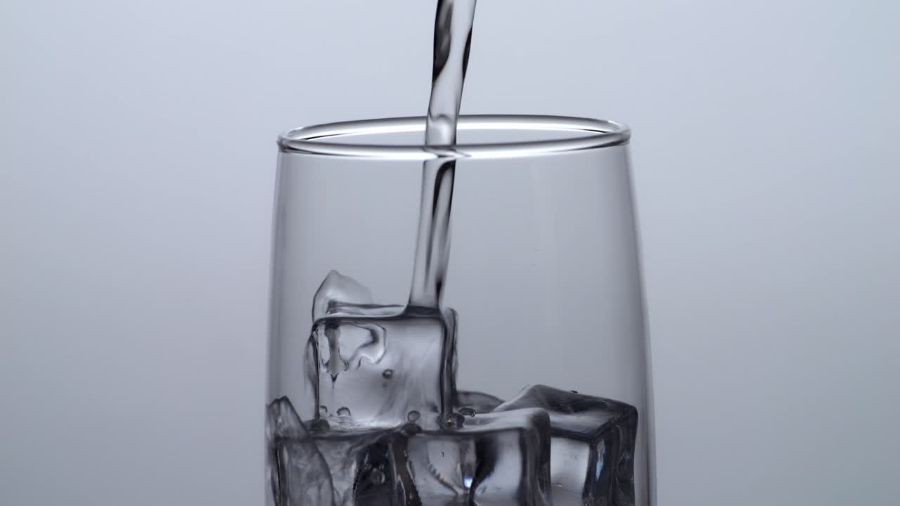 el agua se vierte en un vaso con hielo