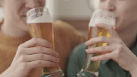 man and woman making sip of beer in cafe