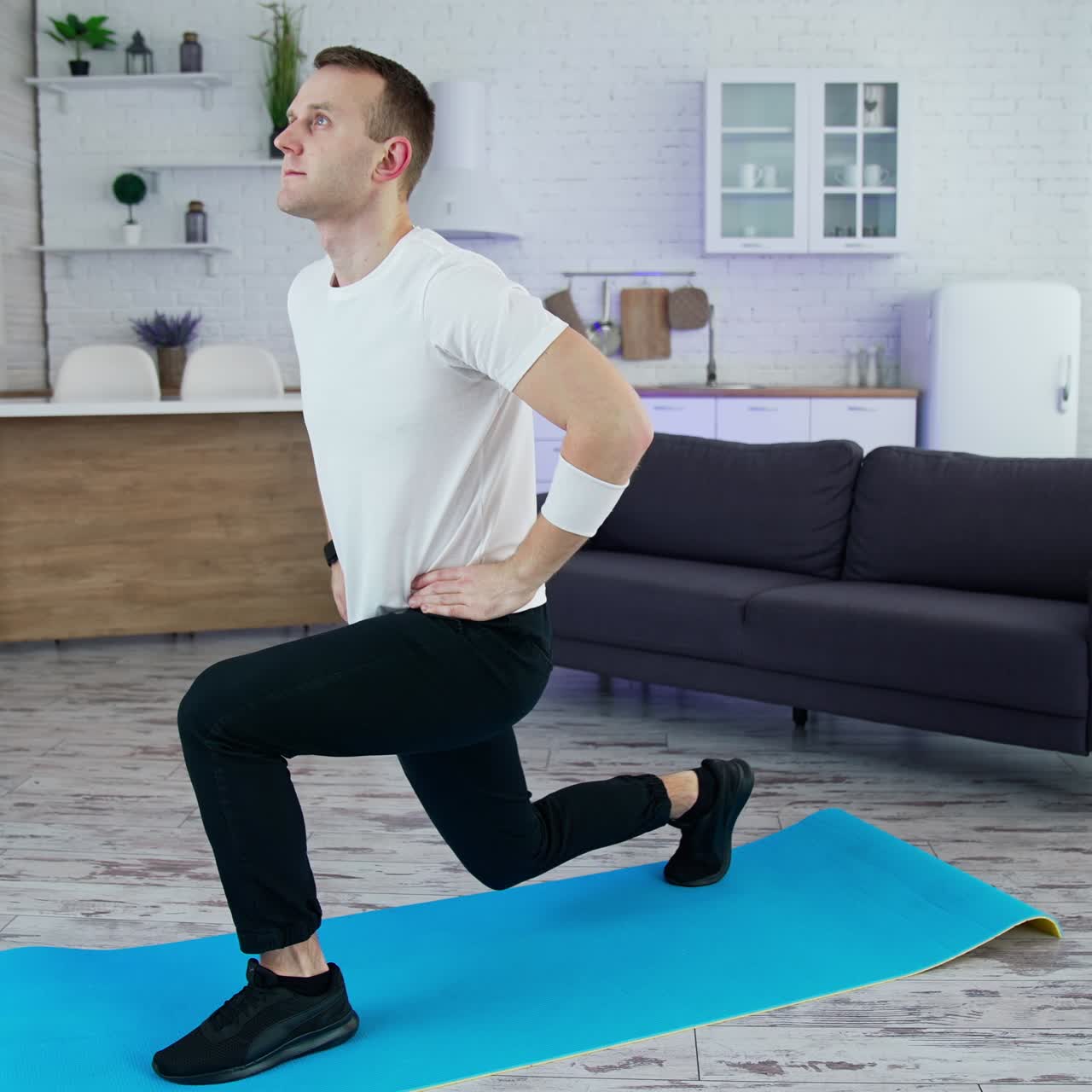 Guy is exercising on a mat at home. Young man holding balance during workout. Home fitness, training and wellness concept. Quarantine