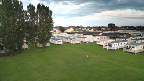 Drone-captures-summer-sunset-in-Skegness,-showcasing-coastal-town,-holiday-park,-beach,-sea,-and-caravans-in-sweeping-scenes