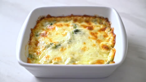 Lasaña de espinacas al horno con queso en placa blanca.