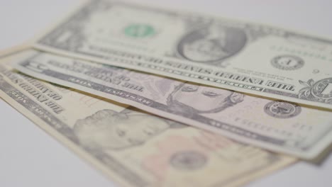 close up currency shot of hand grabbing us dollar bills on white background