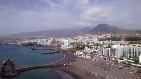 Luftaufnahme-Eines-Schwarzen-Sandstrandes-In-Der-Nähe-Der-Touristenstadt-Teneriffa