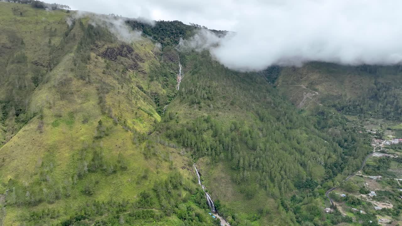 catarata de efrata en sumatra con nubes que envuelven las montañas verdes y exuberantes, vista aérea