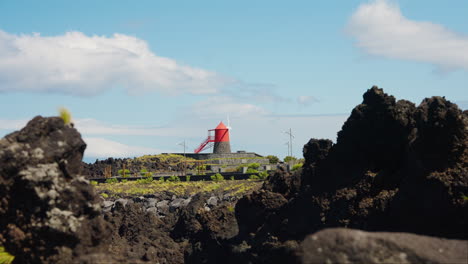 Static-shot-of-red-windmill-situated-at-the-rocky-coastline