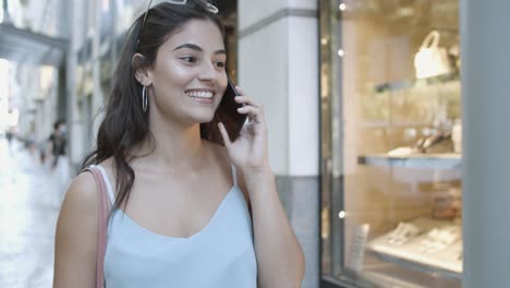 cheerful pretty young woman talking on mobile phone and smiling