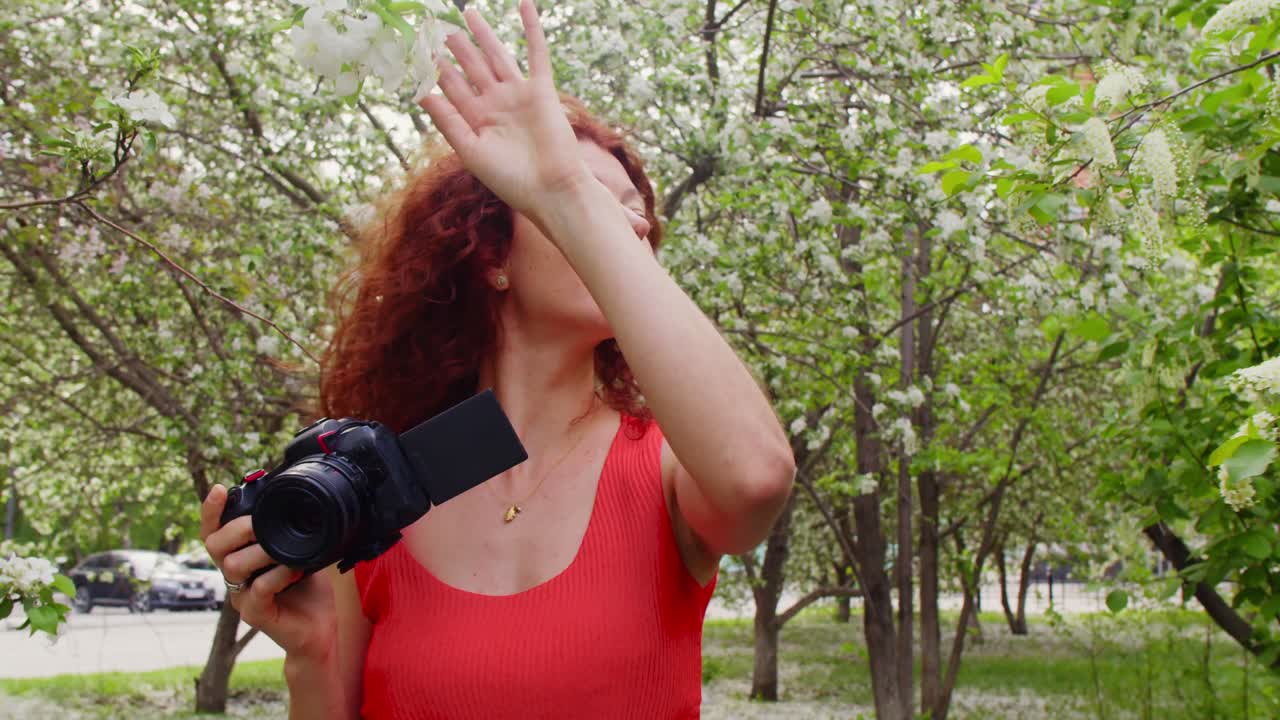 Woman photographing spring blossoms in a park